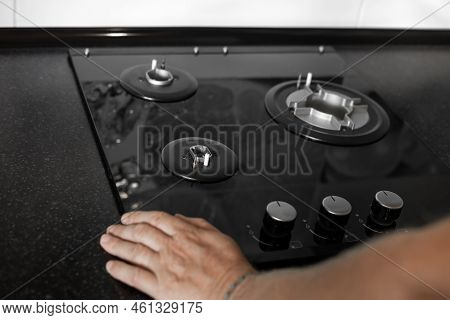 Installation Of A Gas Three-burner Built-in Stove In A Black Countertop. Kitchen Interier.