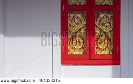 Sunlight And Shadow On Surface Of Red Wooden Window With Golden Traditional Kranok Pattern On White 