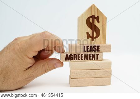 Real Estate And Business. On Wooden Blocks With The Inscription - Lease Agreement, There Is A Model 