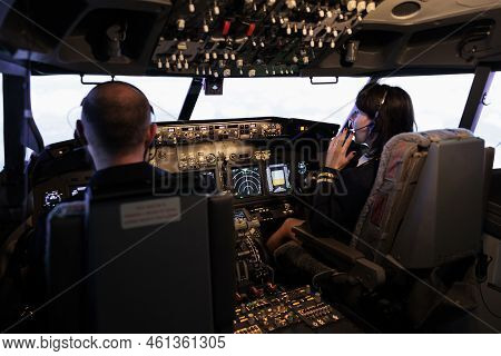 Male Captain And Copilot Flying Airplane With Control Command On Dashboard Navigation, Looking Throu