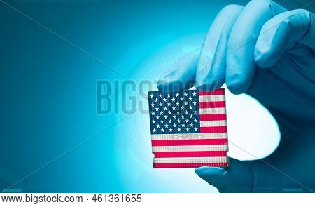 Electronic Engineer Hand Holding Computer Chip With American Flag On Blue Background. Chipset Of Ele