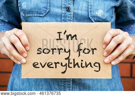 Woman Hands Holding Piece Of Cardboard With Words  I Am Sorry For Everything Against Brick Wall Back