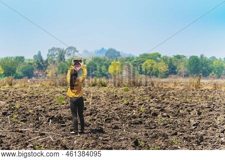 Female Farmer Use Tablet To Take Wide Angle Shots Of Land To Make Farming Decisions In Soil Field. W