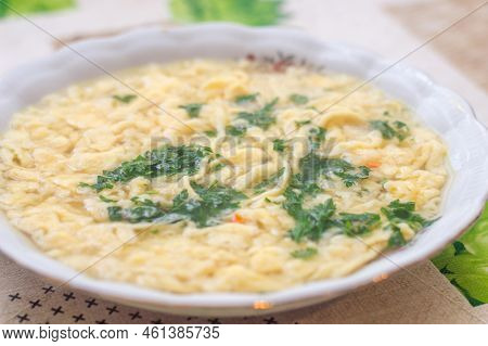 Plate With Polish Traditional Beef Broth With Lane Kluski Noodles And Parsley.