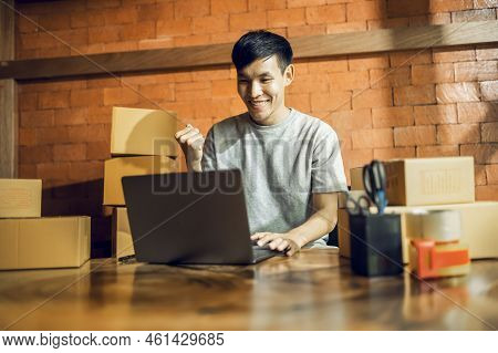 An Asian Man Uses A Mobile Phone To Take Orders And Display Items In A Box That Records Live Streami