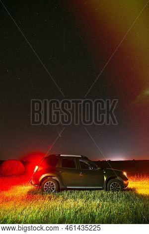 Renault Duster Or Dacia Duster Suv In Night Summer Meadow Landscape With Hay Bale After Harvest. Dus