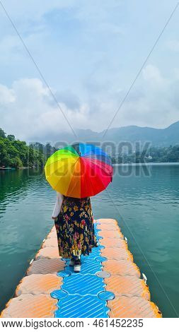 Young Woman Standing On Plastic Pier With The Stunning View Of Mountains Fog, Clouds And Trees Over 