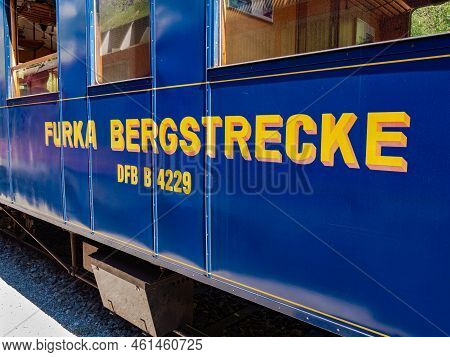 Gletsch, Switzerland - July 15, 2022: A Wagon Of The Furka Steam Train Through The Mountain Landscap