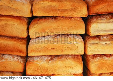 Freshly Baked Loaves Of Bread Lie Piled Up, One On Top Of The Other. Bakery.