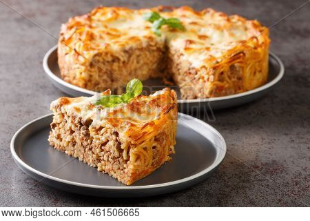 Cheesy Baked Spaghetti Pie With Ground Beef, Spicy And Tomato Sauce Closeup In The Plate On The Tabl