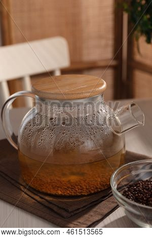 Glass Teapot With Aromatic Buckwheat Tea And Granules On Wooden Table
