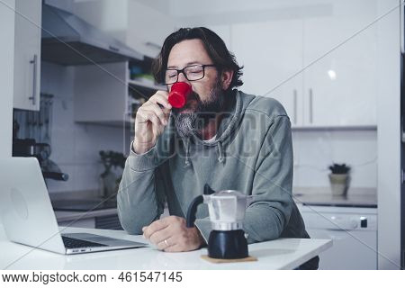 One Mature Man At Home Having A Coffe In The Morning In The Kitchen. Single People Lifestyle. Modern