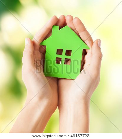 photo de gros plan des mains de femme tenant la maison verte