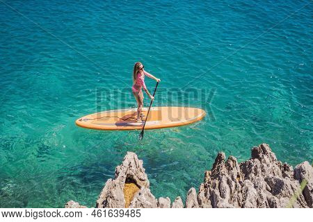 Young Women Having Fun Stand Up Paddling In Blue Water Sea In Montenegro. Sup. Girl Training On Padd