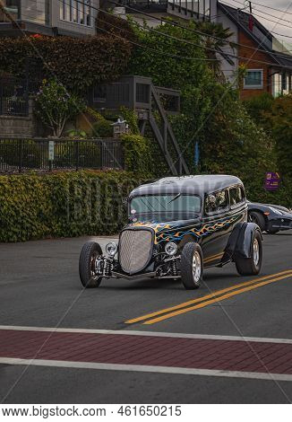 A 1933 Ford Roadster At The Rally Car Shows. Vintage Ford Highboy Hot Rod Driving In The Downtown Wh