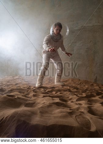 Fear Of The Unknown On Alien Planets. An Astronaut In A White Spacesuit Walks Through An Abandoned C
