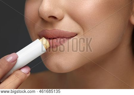 Lips Protection. Close Up Beautiful Woman Lips Applying Lip Balm, Lipcare Stick On. Lips Skin Care C