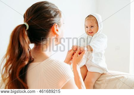 Little Girl Her Mother Play Sitting On Couch Mother Hold Child Hands Turns Them In Different Directi