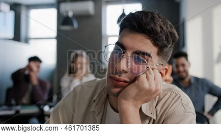 Close-up Depressed Worried Young Caucasian Guy Student Sitting At Desk Alone Suffering From Bullying