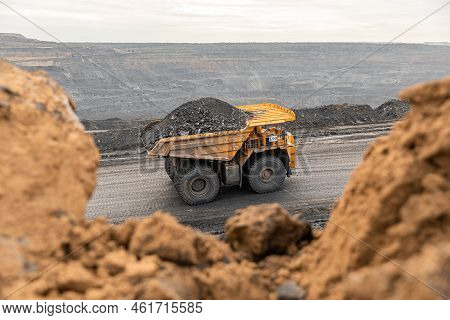 Large Quarry Dump Truck. Big Yellow Mining Truck At Work Site. Loading Coal Into Body Truck. Product