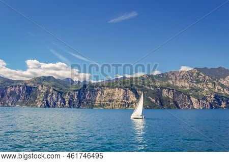 Sailing Alone In Lake Garda With Dramatic Landscape Near Riva Del Garda, Northern Italy