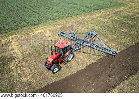 Large Agricultural Machine Cultivates The Land. The View From The Top. Plowing Land For Planting Cro