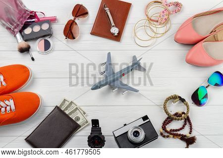Flat Lay Mens And Womens Accessories And Toy Plane. White Wooden Desk Background.