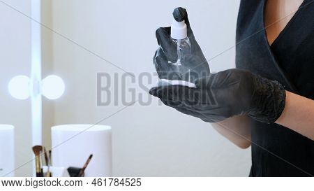 Beauty Saloon. Close-up, The Master In Black Special Gloves Holds A Cotton Pad And Sprinkles It With