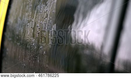 Close-up, On The Car Glass Windows Rain Drops Drip Down A Multitude Of Streams. Its Raining Heavily,