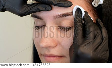 Beauty Saloon. A Close-up, The Master Wipes The Eyebrow Area With A Cotton Disc Moistened With Antis