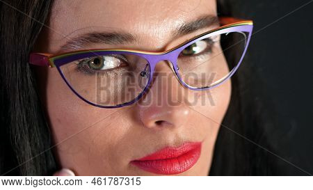 Portrait Of A Sexy Brunette Woman With Red Lips Who Eroticly And Playfully Tries On Stylish Glasses,