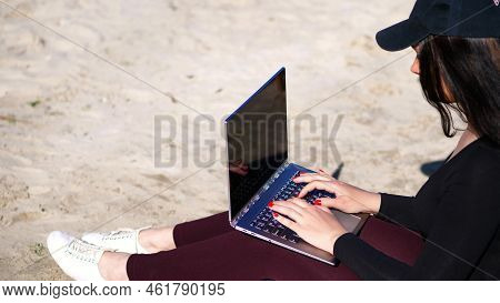 Summer, Sea Beach. Sunrise, Beautiful Woman In A Black Cap, Blaser Is Working On Laptop
