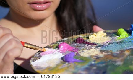 Summer, Outdoors, Close-up Of A Palette With Paints, The Woman Artist Mixes Paints With A Brush On T