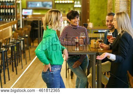 Blond Female With Glass Of Wine Telling Story To Diverse Male And Female Friends While Gathering Aro