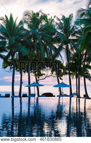 Tropical Pool With Palm Trees And Beach Bed Chairs, Beach Chairs With Beach Towel At A Pool