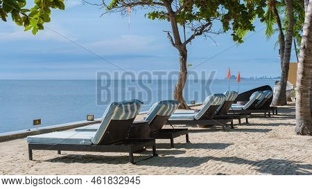 Tropical Pool With Palm Trees And Beach Bed Chairs, Beach Chairs With Beach Towel At A Pool