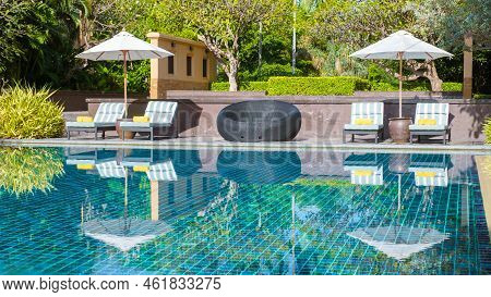 Tropical Pool With Palm Trees And Beach Bed Chairs, Beach Chairs With Beach Towel At A Pool