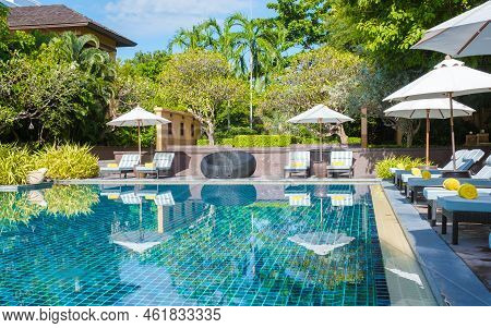 Tropical Pool With Palm Trees And Beach Bed Chairs, Beach Chairs With Beach Towel At A Pool