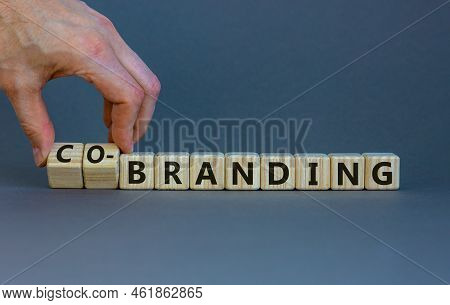 Branding Or Co-branding Symbol. Businessman Turns Wooden Cubes And Changes The Word Branding To Co-b