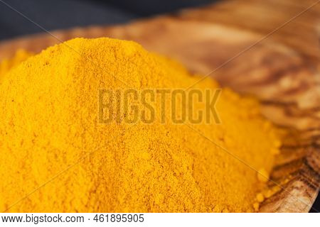 Turmeric Powder In Wooden Spoon Studio Shoot