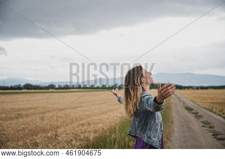 Serene Young Woman Standing And Meditating Or Practicing Breathwork On A Country Road Surrounded Wit