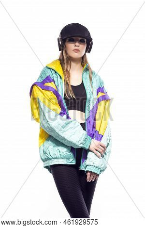 Winsome Sportwoman In Fitness Outfit And Baseball Cap With Wireless Headphones Listening Music While