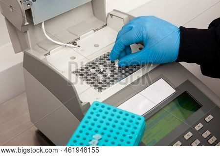 Closeup Of A Scientist Hand While Working At The Laboratory With A Thermal Cycler. Polymerase Chain 