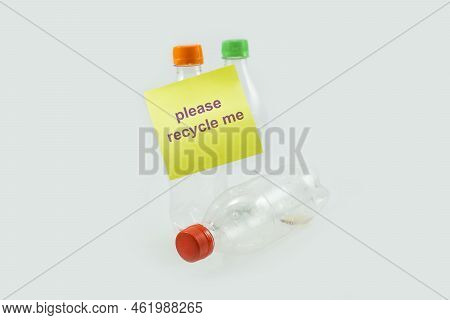 Close-up Of Used Plastic Bottles For Recycling With Sticky Notes Please Recycle Me Isolated On A Whi