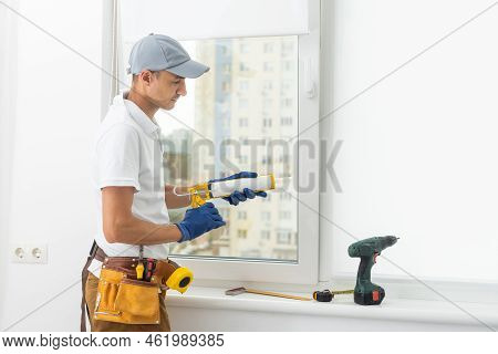 A Repairman Repairs, Adjusts Or Installs Metal-plastic Windows In The Apartment. Glazing Of Balconie