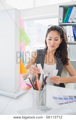 Concentrated female photo editor at work in a bright office