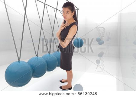 Thoughtful businesswoman against blue newtons cradle