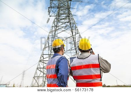 Two Workers Wearing Protective Helmet Works At Electrical Power Station