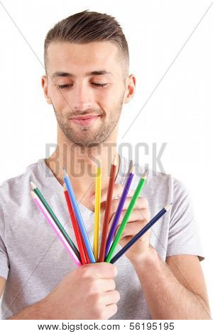 A handsome man chooses a colored crayon.  All isolated on white background.