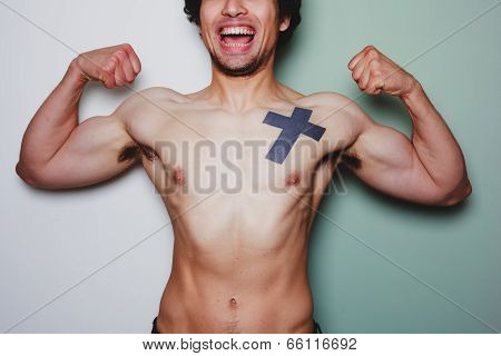 Young Athletic Man With Tattoo Flexing His Muscles